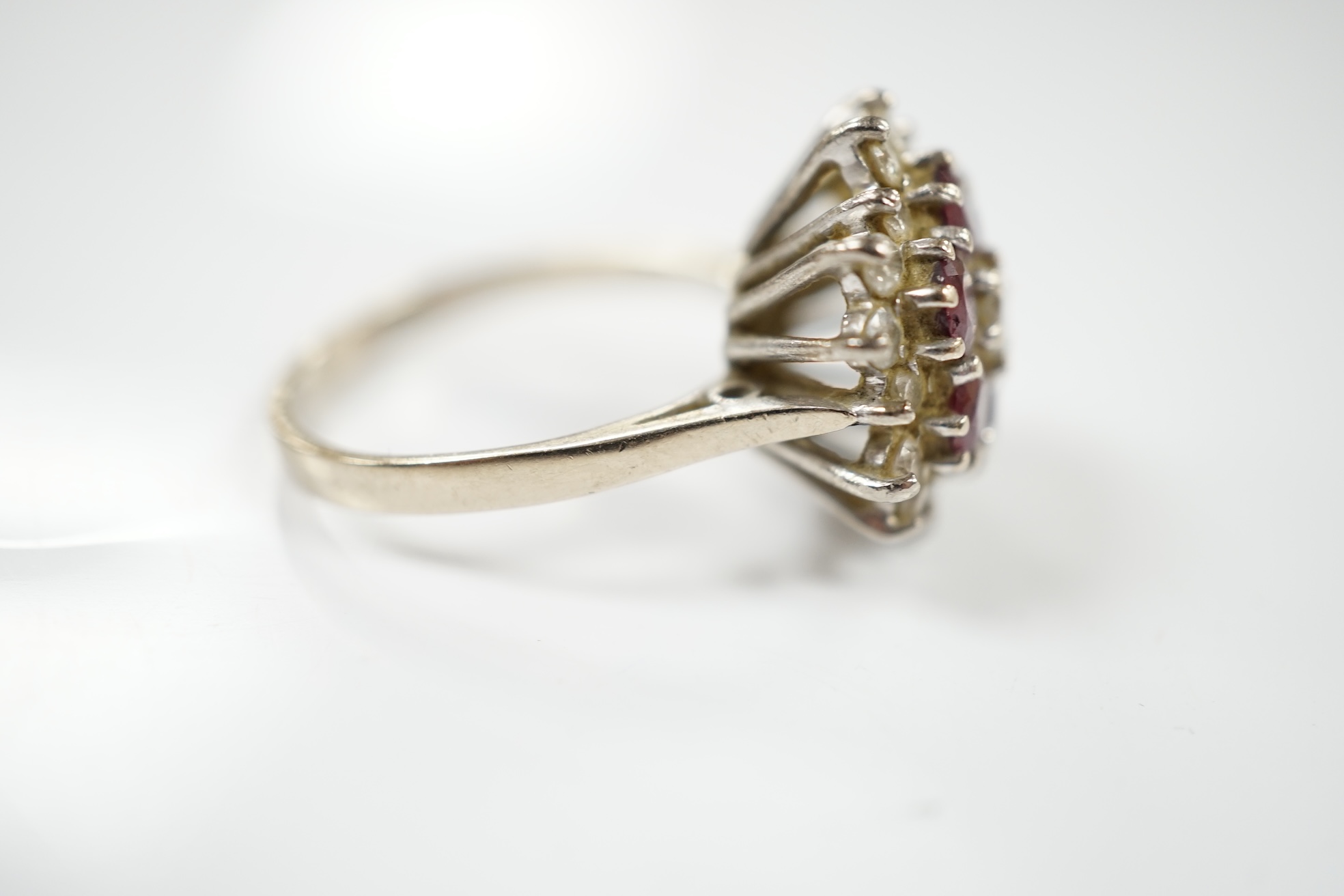 An 18ct white metal, ruby and diamond cluster ring, size P, gross weight 7 grams. Condition - fair